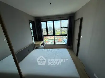 Modern bedroom with large window offering stunning city view, minimalist design and ample natural light.