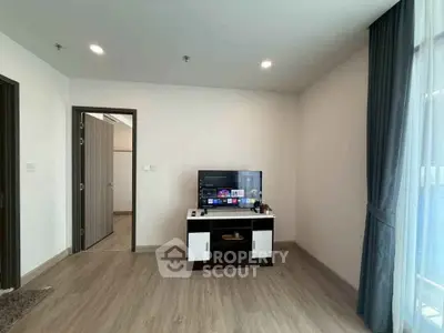 Modern living room with sleek TV stand and large window for natural light.