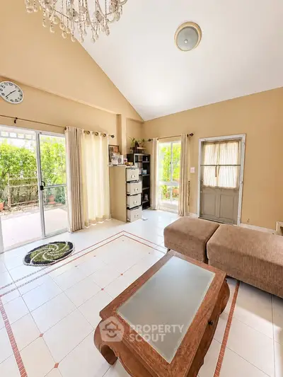Spacious living room with natural light and garden view, featuring elegant decor and comfortable seating.