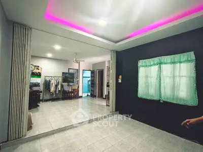Spacious living area with modern lighting and tiled flooring, perfect for family gatherings.