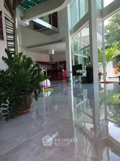 Luxurious modern living room with high ceilings and large windows offering abundant natural light.