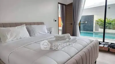 Luxurious bedroom with pool view, featuring elegant decor and plush bedding for ultimate comfort.
