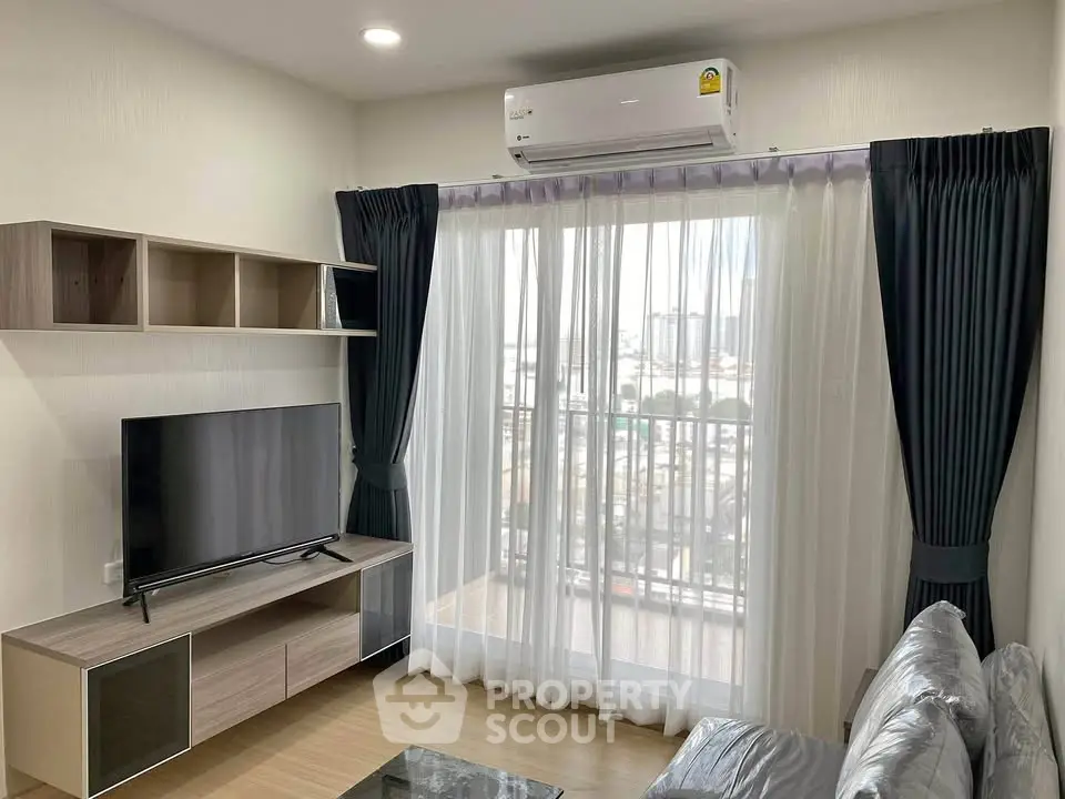 Modern living room with sleek furniture and balcony view, featuring a large TV and air conditioning.