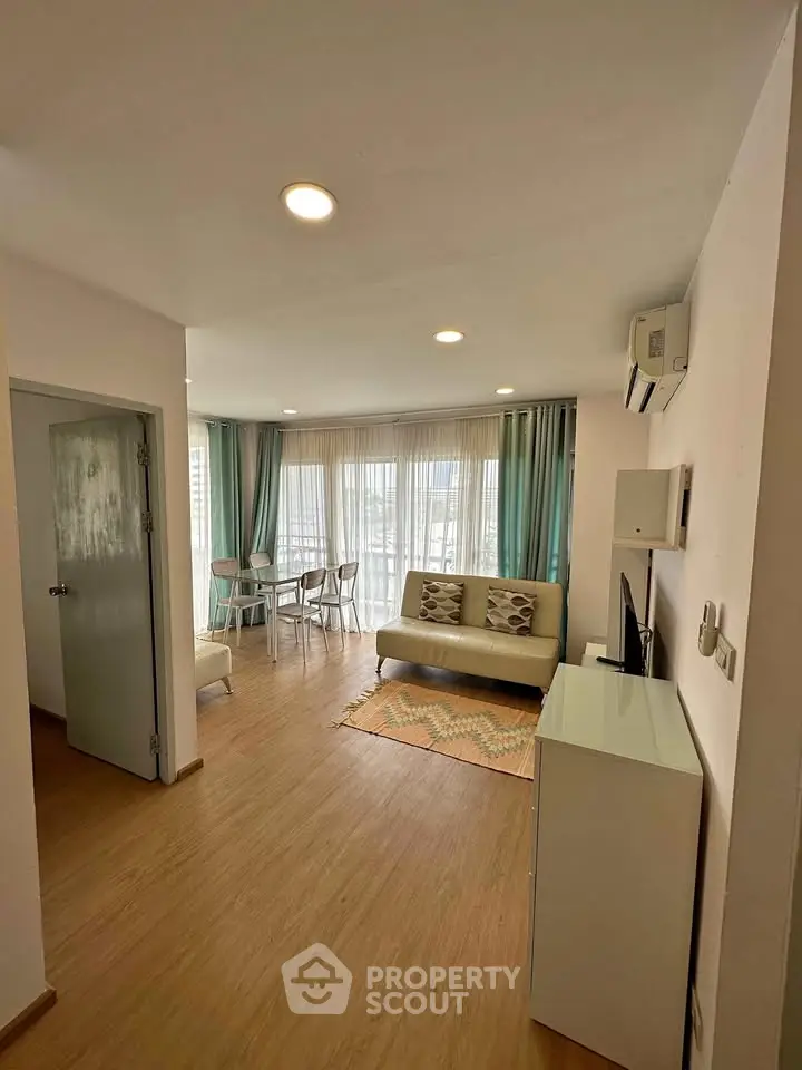 Modern living room with stylish decor and natural light, featuring a cozy sofa and dining area.