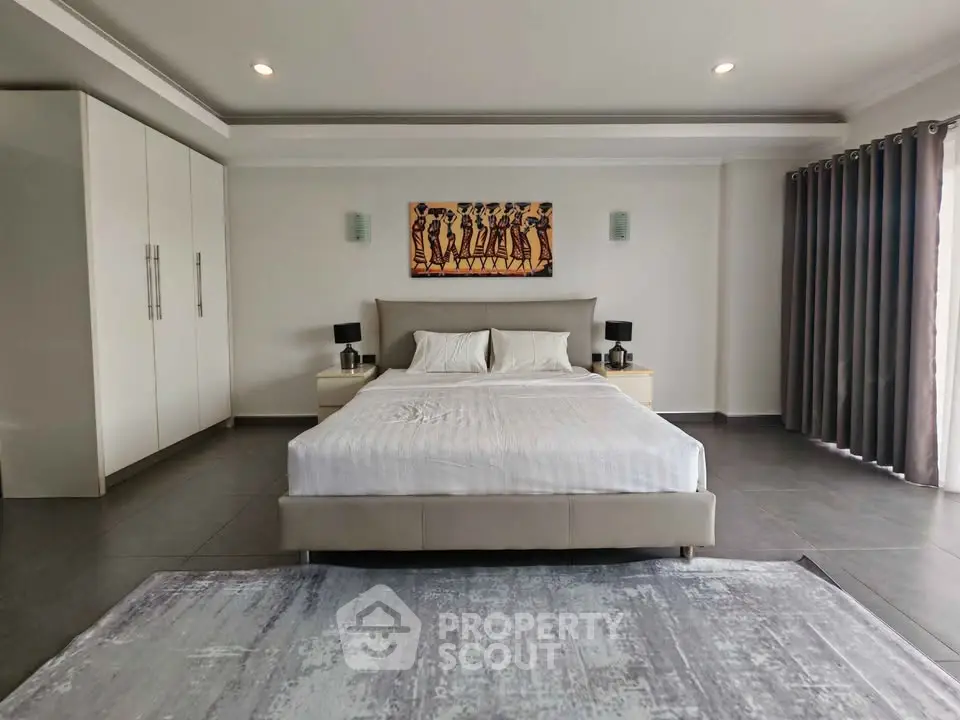 Spacious modern bedroom with elegant decor and ample natural light