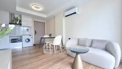Modern living room with sleek furniture and integrated kitchen appliances in a bright, airy space.