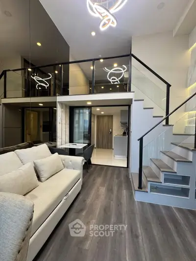 Modern loft apartment with stylish interior, featuring a cozy living area and sleek staircase leading to an upper level.