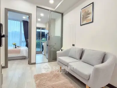 Modern apartment interior with cozy living room and view into bedroom, featuring stylish decor and natural light.