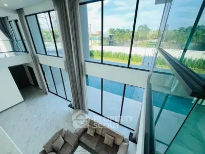 Luxurious modern living room with floor-to-ceiling windows and pool view