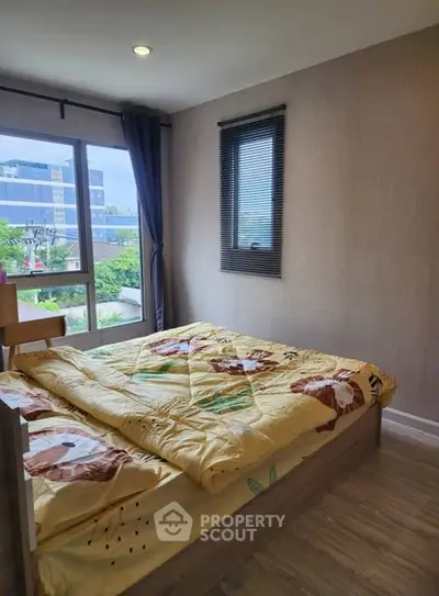 Cozy bedroom with large window and modern decor, perfect for relaxation.