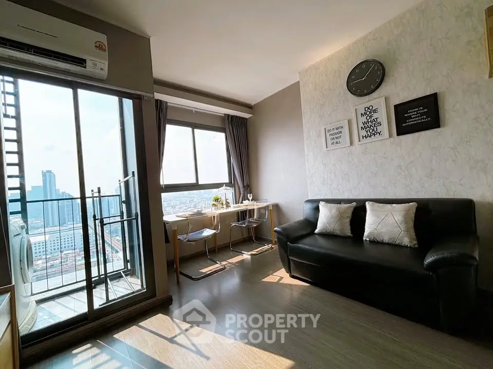 Modern living room with balcony and city view, featuring stylish decor and ample natural light.