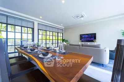 Spacious modern living room with elegant dining area and large windows offering natural light.
