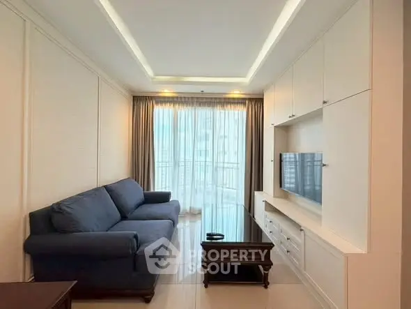 Spacious living room with modern furnishings and large window offering natural light.