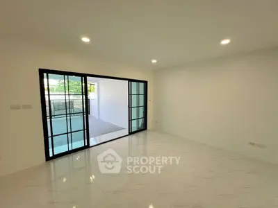 Spacious modern living room with sliding glass doors and elegant tile flooring