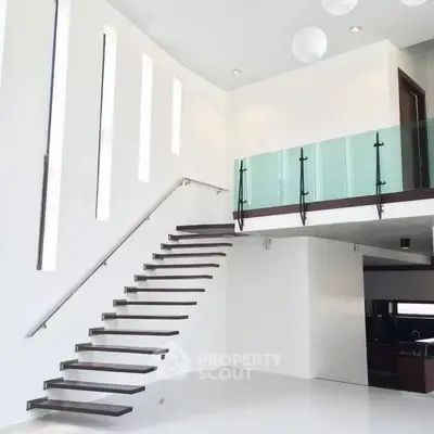 Modern minimalist interior with floating staircase and glass balcony in luxury home