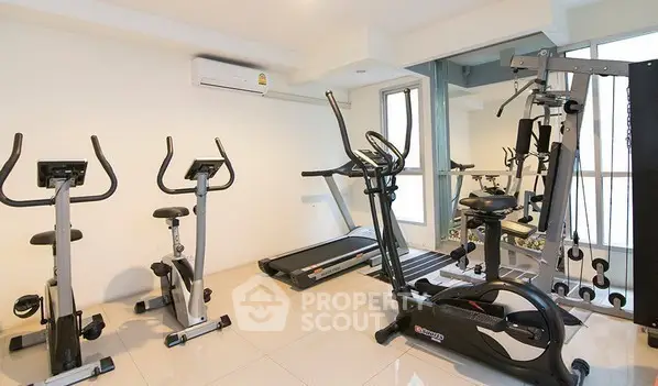 Modern gym with exercise bikes and treadmill in a bright, spacious room.