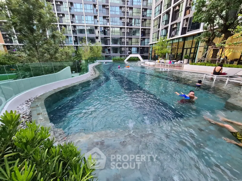Luxurious condominium swimming pool with modern design and lush greenery