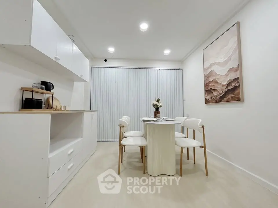Modern dining area with elegant white furniture and minimalist decor