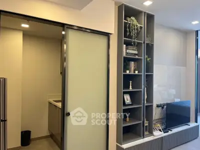 Modern living room with sleek shelving and sliding door to kitchen