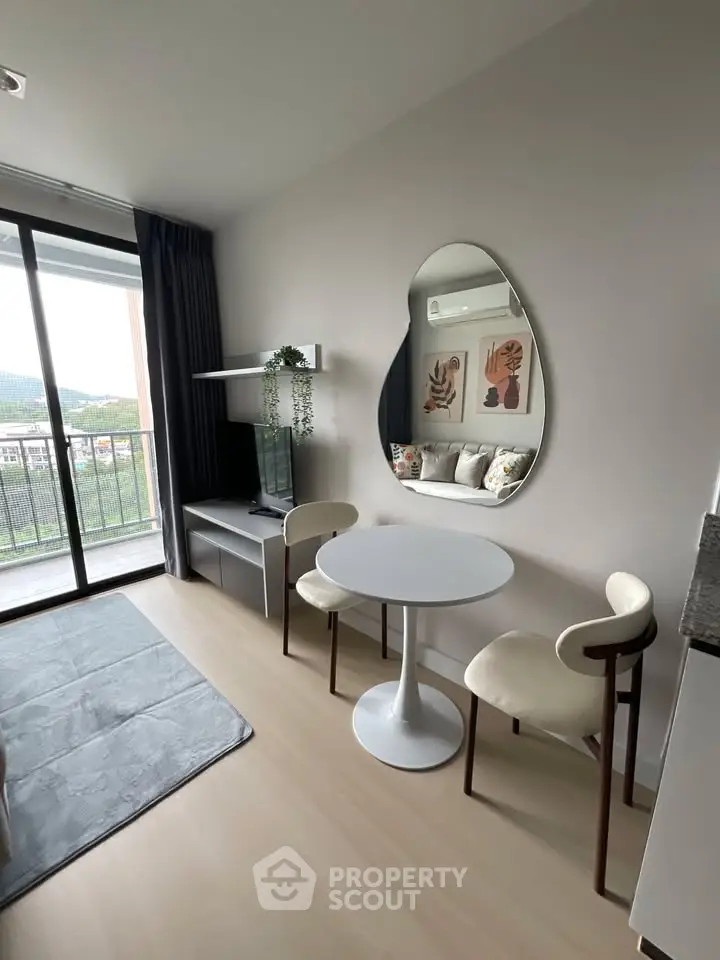 Modern living room with stylish decor and balcony view in a contemporary apartment.