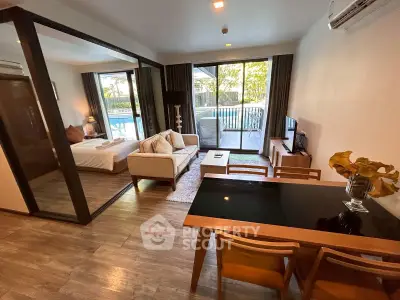 Modern open-plan living room with pool view, featuring stylish furniture and elegant decor.