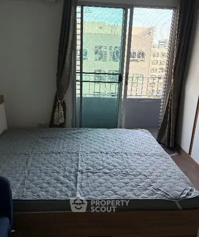 Cozy bedroom with large window and balcony view in modern apartment