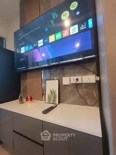 Modern living room with wall-mounted TV and sleek cabinetry