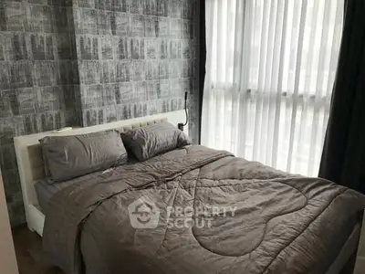 Cozy modern bedroom with stylish decor and large window for natural light.