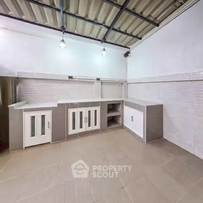 Spacious kitchen with modern cabinetry and tiled backsplash in a contemporary home.
