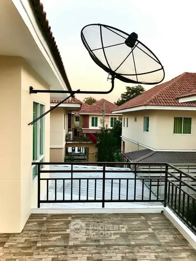 Spacious balcony with satellite dish and scenic neighborhood view, perfect for relaxation and entertainment.