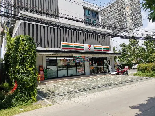 Modern commercial building with parking space and greenery, ideal for retail business.