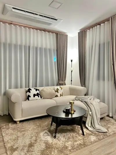 Elegant living room with plush sofa, cozy rug, and stylish decor for modern comfort.