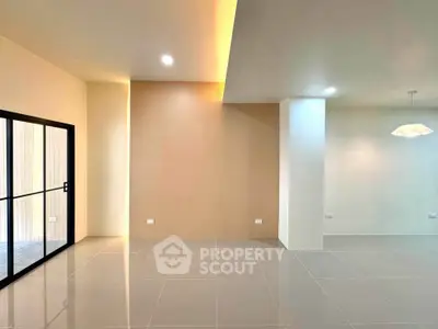 Spacious modern living room with sleek tile flooring and large glass doors.