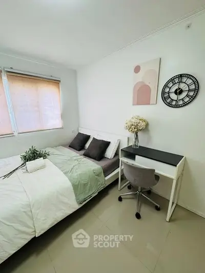 Modern bedroom with stylish decor and workspace, featuring a cozy bed and elegant wall art.