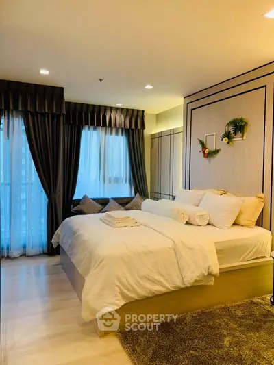 Luxurious bedroom with elegant decor and large windows offering natural light.