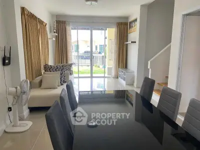 Spacious modern living room with elegant dining area and large windows for natural light.