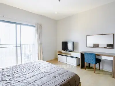 Spacious bedroom with modern decor and large window offering city views.