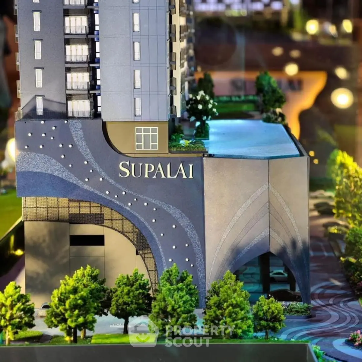 Modern high-rise building model with lush landscaping and elegant architectural design.