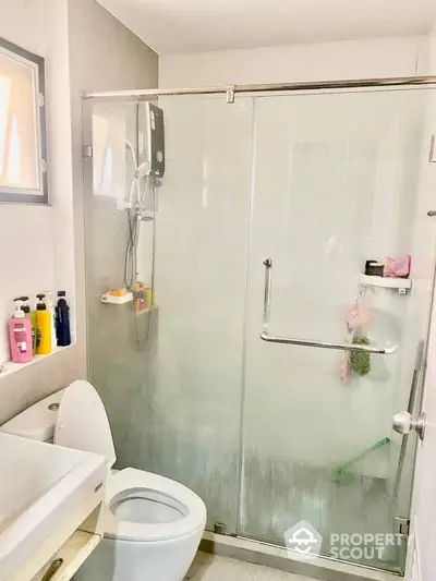 Modern bathroom with glass shower enclosure, sleek fixtures, and well-lit ambiance, perfect for a refreshing start to the day.