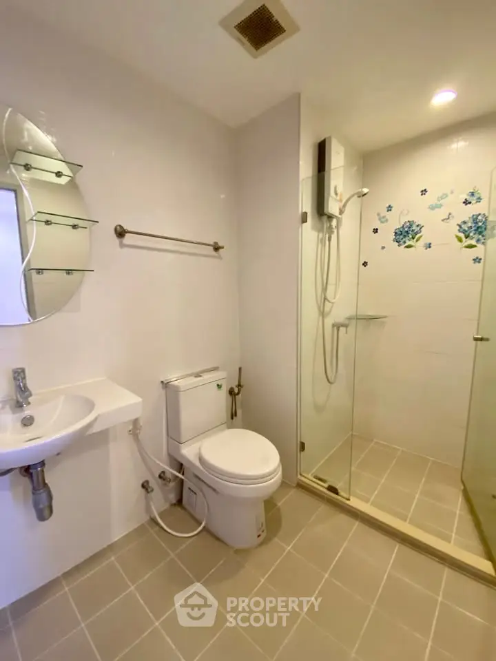 Modern bathroom with glass shower and sleek fixtures in a contemporary apartment.