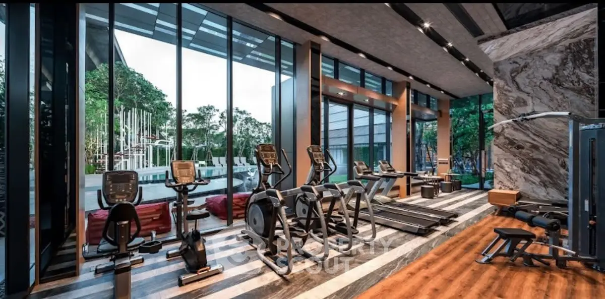 Luxurious modern gym with state-of-the-art equipment and pool view, perfect for fitness enthusiasts.