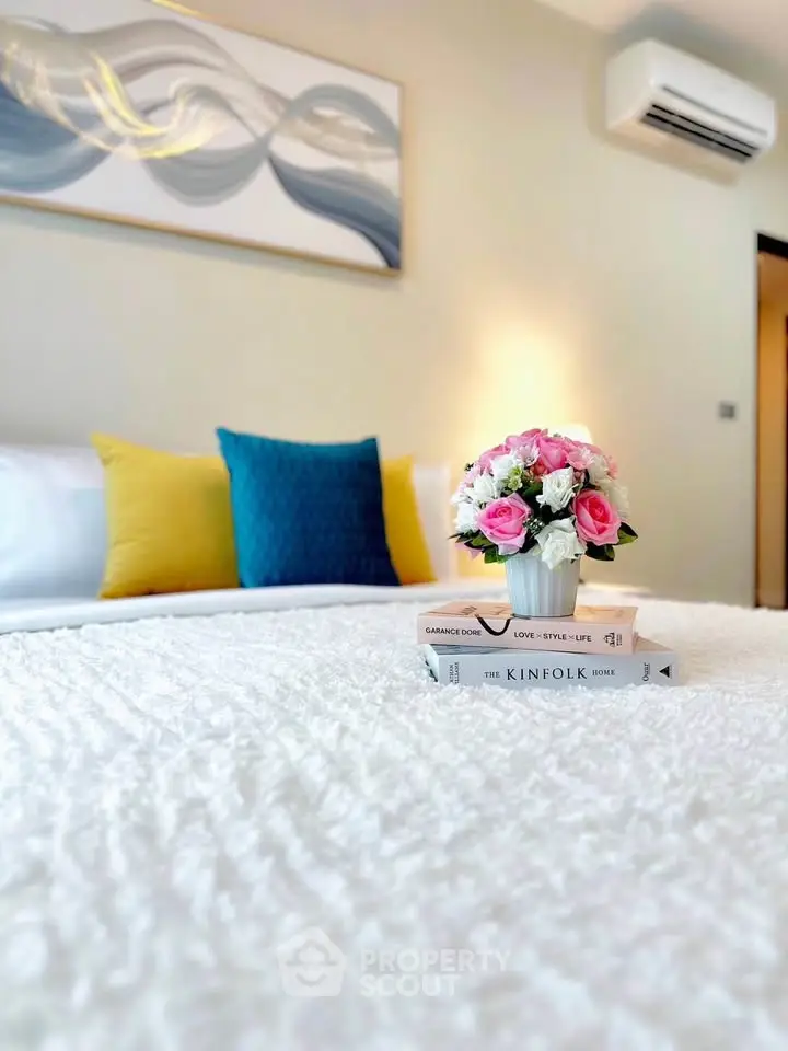 Elegant bedroom with stylish decor, plush bedding, and modern air conditioning unit.