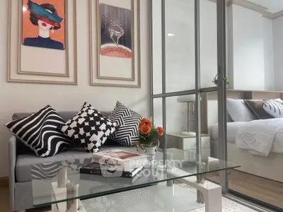 Stylish modern living room with glass coffee table and cozy bedroom view
