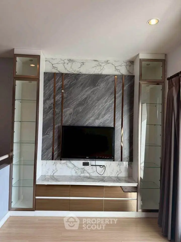 Modern living room with elegant marble TV wall and sleek glass cabinets