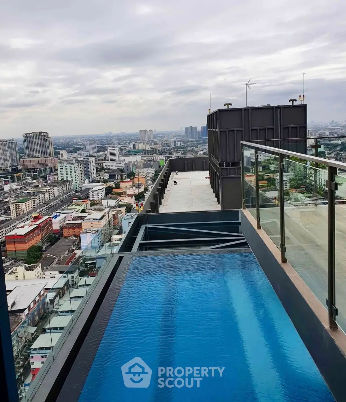 Stunning rooftop pool with panoramic city views in a modern high-rise building.