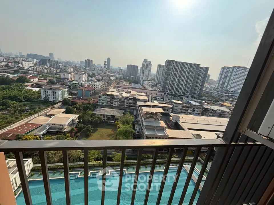 Stunning cityscape view from a high-rise balcony overlooking a luxurious swimming pool.