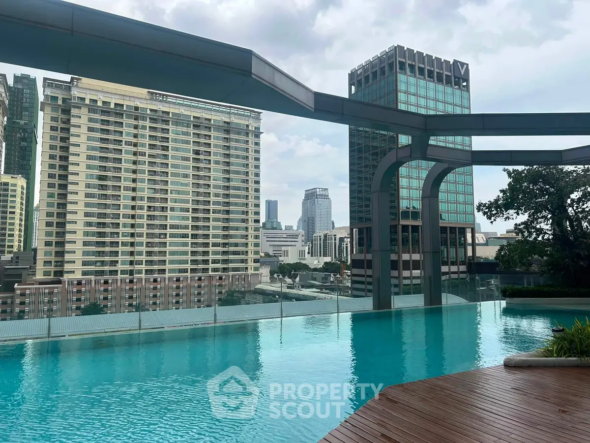 Luxurious rooftop pool with stunning city skyline views in a modern high-rise building.