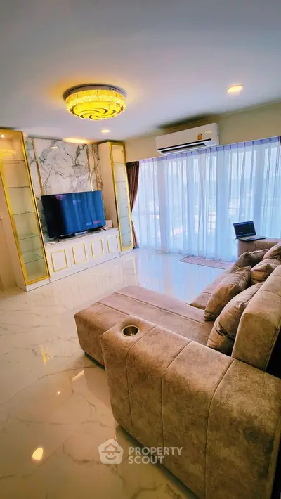 Luxurious living room with marble accents and plush seating, featuring a modern entertainment setup and elegant lighting.