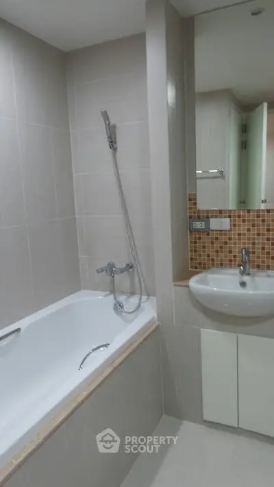 Modern bathroom with sleek design featuring a bathtub and stylish sink area.