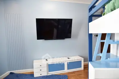 Modern living room with wall-mounted TV and stylish blue decor